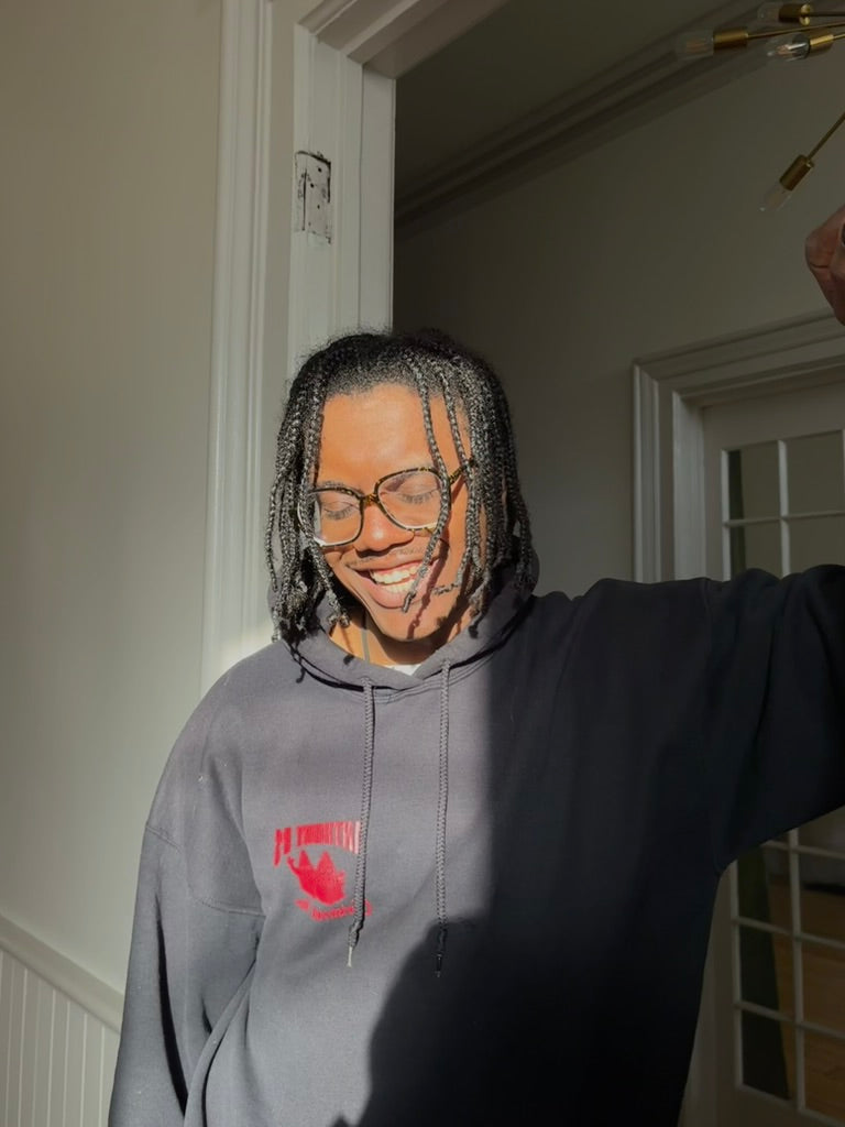 JW stands in a doorway smiling with the sun on his face